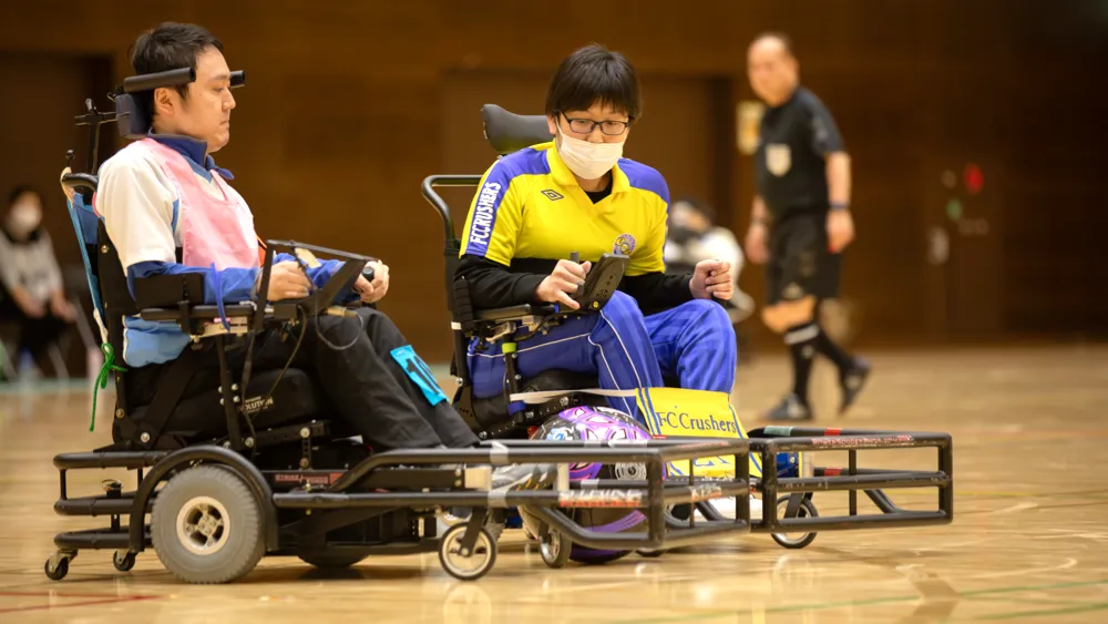 電動車椅子サッカーの試合でボールを追う選手たち（横浜ベイドリーム vs FCクラッシャーズ）